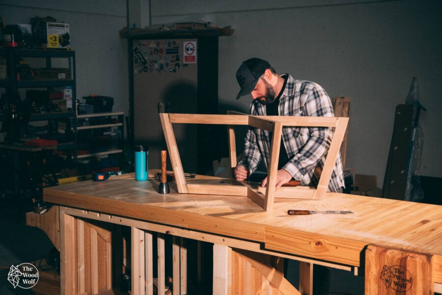 Artesano trabajando una estructura de madera maciza en su taller, respetando el ritmo del material