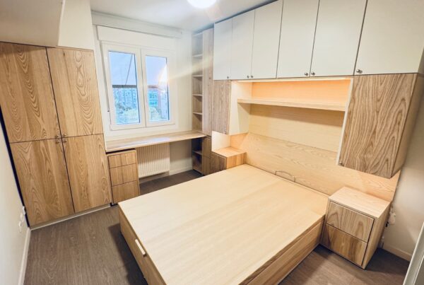 Dormitorio a medida con armarios, cama y escritorio integrados en fresno rechapado y frentes lacados mate, diseñado y fabricado por The Wood Wolf.