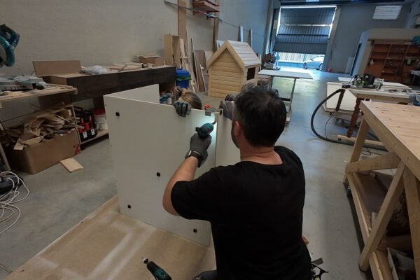Proceso de ensamblaje de un armario bajo escalera a medida utilizando herrajes de precisión en el taller de The Wood Wolf.